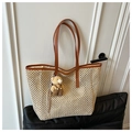 Detail of woven straw tote bag featuring brown leather straps and a cute bear charm - White with Pendant