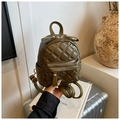 Detailed shot of an olive green quilted mini backpack with a decorative bow and gold zippers - Green