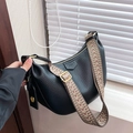 Black dumpling crossbody bag with geometric woven strap and lychee leather texture - Black