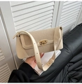 Detalle del bolso de hombro en cuero crema con hebilla de metal dorado y textura de tela tejida - Blanco