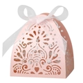 Close-up of pink laser-cut favor box with floral patterns and a white organza ribbon bow - Pink