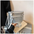 Detail of silver metallic saddle bag with long leather zipper pulls on front pockets - Silver