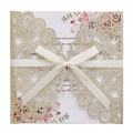 Close-up of glitter champagne gold laser-cut wedding invitation with ivory ribbon and floral insert - Light Gold Glitter