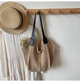 Detail of woven straw tote bag with black leather straps and drawstring closure - Khaki