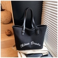 Détail d'un grand cabas noir en toile avec lettrage blanc et poignées en cuir élégantes - Noir