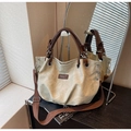 Detail of vintage canvas tote bag with brown leather handles on dark wooden surface - Off-white