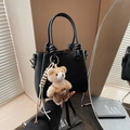Elegant black lychee leather handbag with a cute brown plush bear charm and knotted handle - Black (With Pendant)