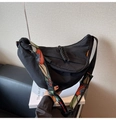 Detail of black nylon crescent bag featuring a wide embroidered colorful shoulder strap - Black