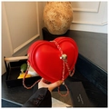Primer plano del bolso rojo en forma de corazón con cadena dorada y hebilla metálica - Rojo