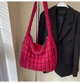 Detail of fuchsia quilted cloud bag showing vibrant texture and wide shoulder strap - Red