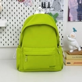 Detail view of neon green nylon backpack with front zipper pocket and GDMNC logo - Green