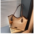Détail du sac cabas en paille tissée avec bordure en cuir marron et breloque ours - Avec Pendentif / Beige