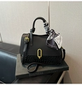 Dettaglio borsa nera a trama intrecciata con chiusura dorata e foulard in seta a fantasia - Nero