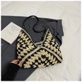 Dettaglio macro della trama intrecciata bicolore e del cinturino in pelle di questa borsa - Beige e Nero