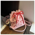 Detail of pink corduroy bucket bag featuring red heart embroidery and drawstring closure - Pink