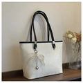 White snakeskin tote bag with black handles and pearl lace bow on wooden table - White and Black