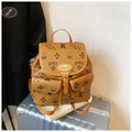 Detail shot of a brown monogram bucket backpack with gold hardware on a suitcase - Brown