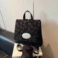 Sac à dos de voyage noir élégant avec texture florale 3D et logo métallique chic - Noir