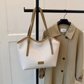 Chic beige lychee leather tote bag with brown straps displayed on a classic trench coat - White Without Pendant