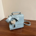 Light blue bow crossbody bag with pearl heart pendant and textured faux leather finish - Blue