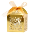 Macro view of gold laser-cut heart candy box with elegant organza ribbon bow - Reflective Gold