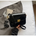 Vue de dessus d'un sac bandoulière en cuir verni noir brillant avec boucle en métal doré - Noir