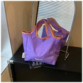 Détail du sac cabas en toile violette avec bordure orange et étiquette MIRFNE sur fond noir - Violet