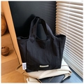 Détail du sac cabas en nylon noir avec étiquette de marque et texture mate élégante - Noir