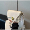 Détail du sac bandoulière beige avec fermoir rotatif doré et ruban en dentelle élégant - Blanc avec pendentif