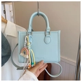Détail d'un sac à main bleu clair en cuir grainé avec des accessoires arc-en-ciel - Bleu (Avec Pendentif)