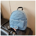 Gros plan du sac à dos en denim matelassé bleu avec fermoir rotatif et détails en cuir - Bleu clair