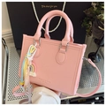 Détail d'un sac à main rose en cuir grainé avec breloque arc-en-ciel et logo texte - Rose (Avec Pendentif)