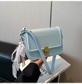 Close-up of light blue rectangle crossbody bag with gold lock and lace pendant - Blue with Charm