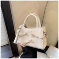 Détail du sac à main crème présentant des nœuds élégants et des accents de perles - Blanc