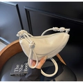 Dettaglio borsa a mezzaluna crema in pelle martellata con cinturino a nodo decorativo - Bianco