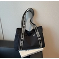 Détail d'un sac cabas en nylon noir avec bandoulière à motifs sur un fond moderne - Noir