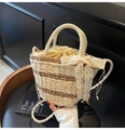 Detalle del bolso tipo cubo de paja tejida con forro de crema y lazo de encaje blanco decorativo - Blanco Roto