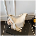 Détail du sac seau blanc cassé en cuir grainé avec un pendentif pompon en peluche - Avec Pendentif / Blanc