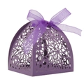 Macro detail of purple laser-cut candy box with intricate floral hollow pattern and ribbon - Deep purple