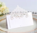 Détail d'un marque-place en dentelle découpée au laser sur de la vaisselle de mariage - Blanc