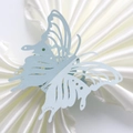 Close-up of laser-cut butterfly napkin ring in light blue with intricate floral details - Pearl Pale Blue