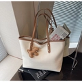 Dettaglio della borsa tote bianca con trama coccodrillo, manici marroni e ciondolo cane - Con Ciondolo / Bianco Sporco