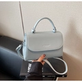 Dettaglio borsa azzurra in pelle martellata con logo in rilievo e manico superiore - Blu