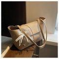 Beige faux leather tote bag with lace bow and pearl pendant on wooden background - Khaki