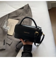 Primer plano de bolso bandolera negro con logo dorado y detalle de asa superior - Negro