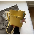 Detail of yellow lychee texture bucket bag with decorative strap and pegasus charm - Yellow with Cloud Pendant