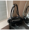 Elegante borsa a cuscino in vernice nera con occhielli in argento e dettagli stile biker - Nero