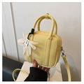 Dettaglio della borsa a mano gialla in pelle martellata con ciondolo a fiore decorativo - Giallo