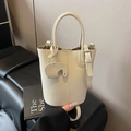 Chic beige lychee leather bucket bag with silver buckle strap and elephant charm pendant - White