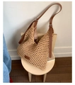 Sac à bandoulière en tricot beige avec sangle en cuir marron sur un tabouret bois - Kaki